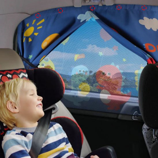 Garçonnet en voiture avec pare soleil voiture bébé sur vitre