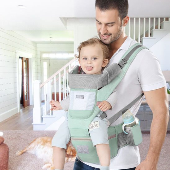  Papa portant bébé en avant dans porte bébé vert 