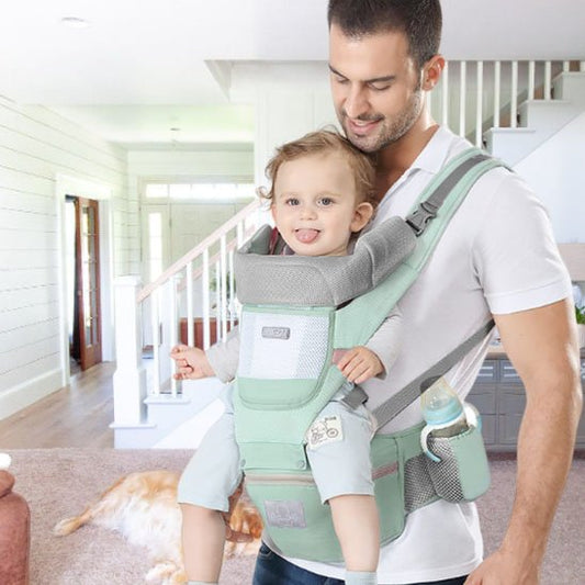  Papa portant bébé en avant dans porte bébé vert 