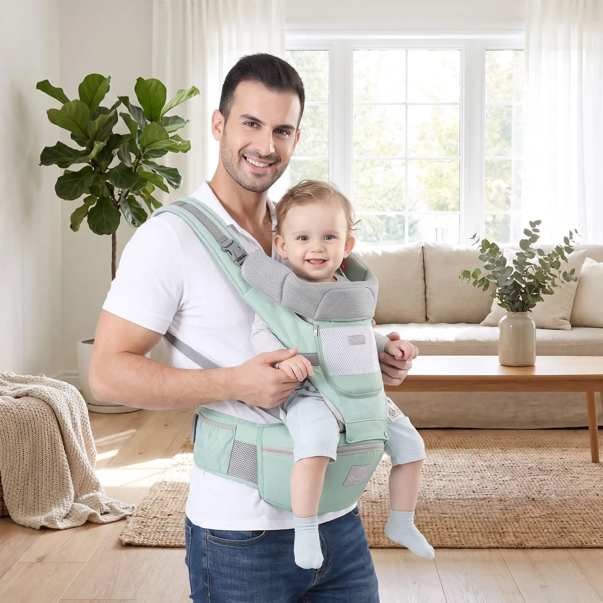 Papa portant bébé en avant dans porte bebe vert