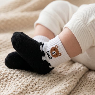 Bébé assis portant chaussette bebe noir  blanc dad ourson