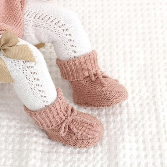 Bébé assise porte chausson bébé rose tricot
