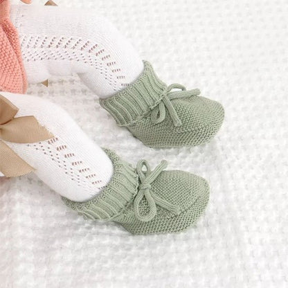 Bébé assise porte chausson bébé tricot vert 