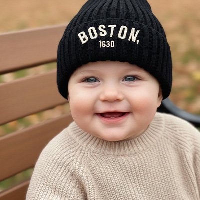 Bébé assit et souriant avec son bonnet bebe noir boston
