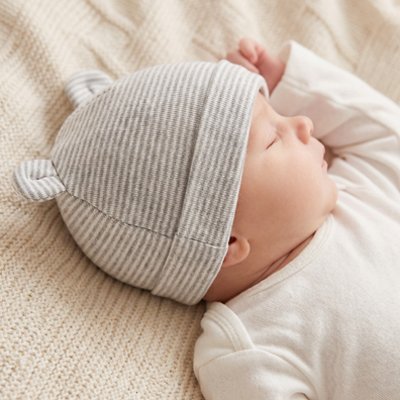 Bébé au lit portant bonnet bebe gris petites oreilles
