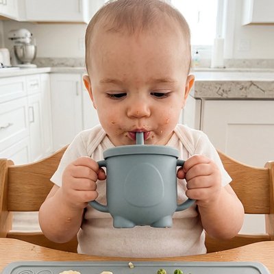 Bébé boit son jus dans gobelet bebe bleu