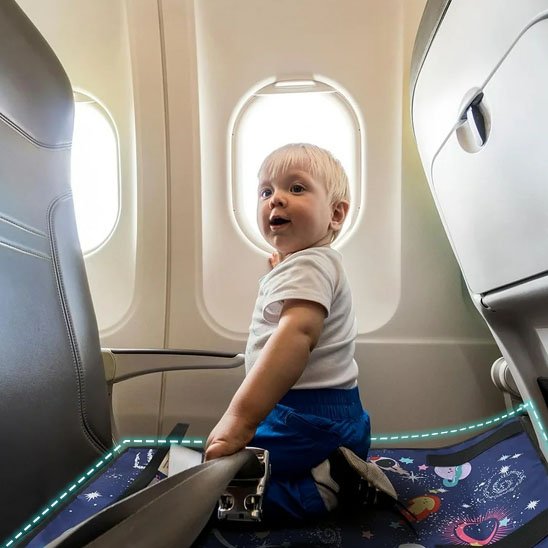 bébé dans avion sur lit de voyage bébé bleu galaxie