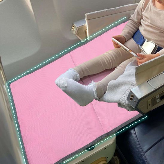 bébé dans avion sur lit de voyage bébé rose