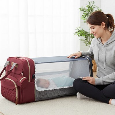 Bébé dans sac à langer pliable rouge bordeaux