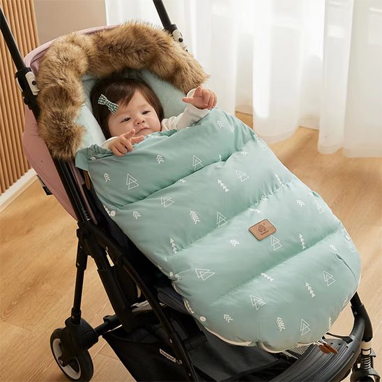 bébé dans une poussette dans chancelière poussette vert doudou