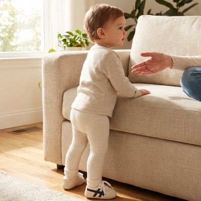 Bébé debout près fauteuil porte chaussure bebe blanc vert
