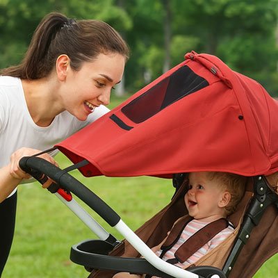 Bébé dehors sous parasol poussette​ rouge