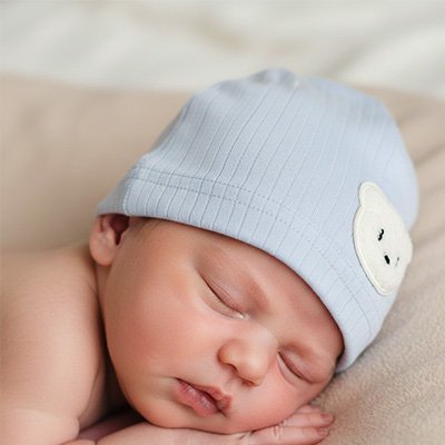bébé dort avec bonnet bleu ourson