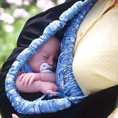 Bébé dort contre maman dans écharpe de portage bleu