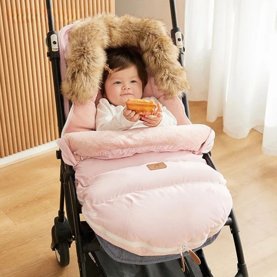 bébé en poussette dans chancelière poussette brun doudou