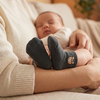 Bébé endormit dans bras maman porte chaussettes bebe noir ours