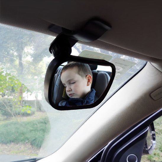 Bébé endormit  en voiture  vu à travers miroir voiture bébé 