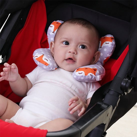 bébé heureux avec cale tête bebe blanc orange dans poussette