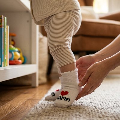 Bébé jouant avec maman porte chaussettes bebe blanc