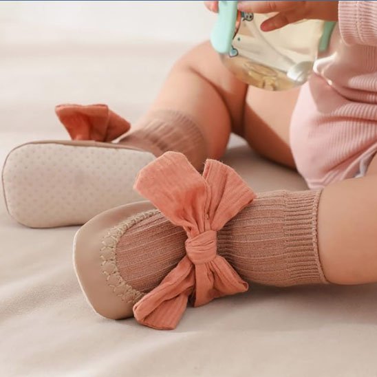 Bébé  jouant porte chaussette bebe  marron avec nœud papillon rose