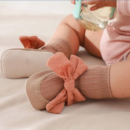 Bébé  jouant porte chaussette bebe  marron avec nœud papillon rose