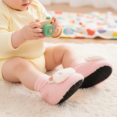 Bébé jouant porte chausson bébé rose chaton
