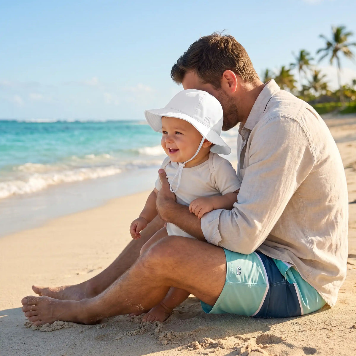 Bébé portant chapeau bebe à plage avec papa