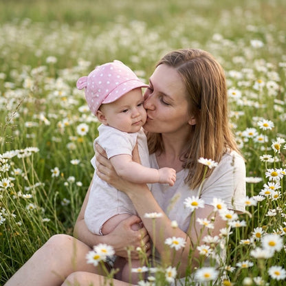 Bébé porte casquette bebe rose dans les champs avec maman