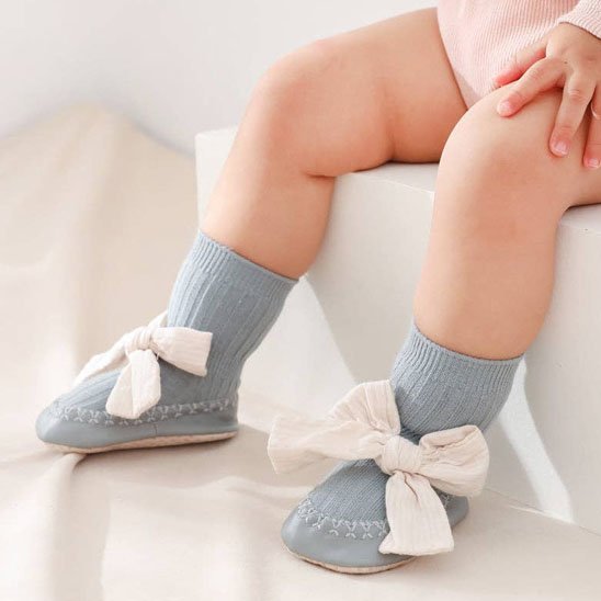 Bébé porte chaussette bebe bleu avec nœud papillon blanc