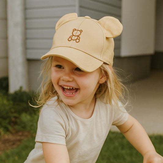 Bébé riant porte casquette bébé kaki ourson