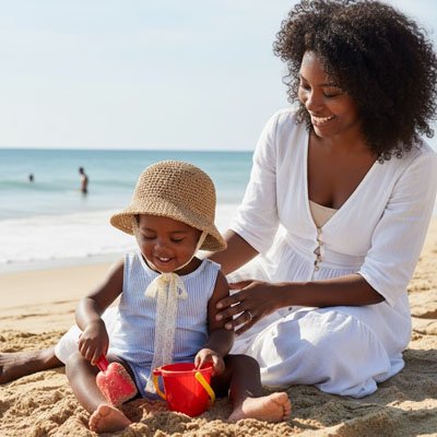 Bébé souriant avec maman porte chapeau bebe en paille