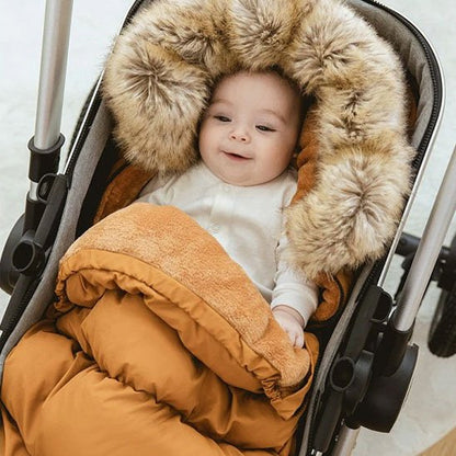 bébé souriant en poussette dans chancelière poussette brun doudou