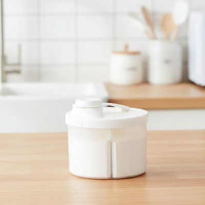 boîte doseuse lait couvercle blanc rempli sur able