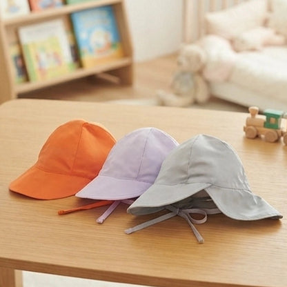 Casquette pour bebe orange violet et gris sur table