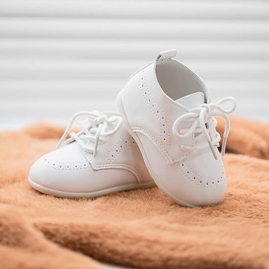 Chaussure bebe blanc lacets posé sur serviette