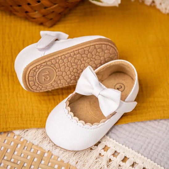 Chaussure bebe fille blanc noeud papillon posé au sol