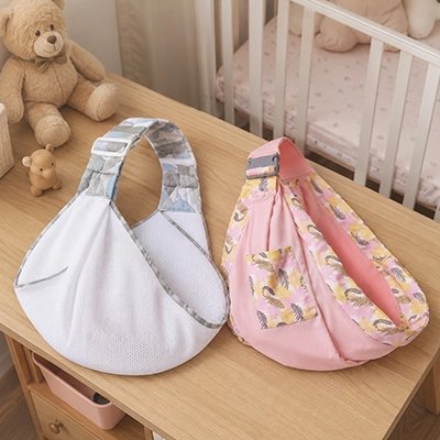 Echarpe de portage blanc et rose sur table de chambre