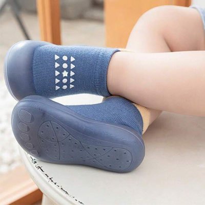 Enfant portant chaussure bebe bleu design croise bien les pieds