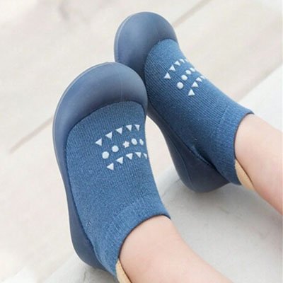 Enfant portant chaussure bebe bleu design tend les pieds