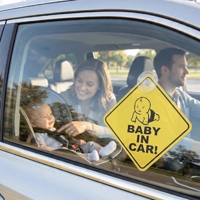 Famille en route avec autocollant bébé à bord sur voiture
