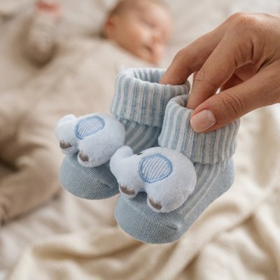  Maman  montre les chaussettes bleu éléphant de bébé
