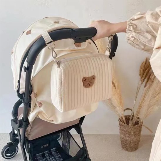 Maman accroche trousse de toilette bebe sur poussette
