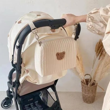 Maman accroche trousse de toilette bebe sur poussette