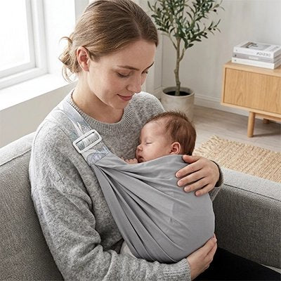 Maman assise tient  bébé dans écharpe de portage gris