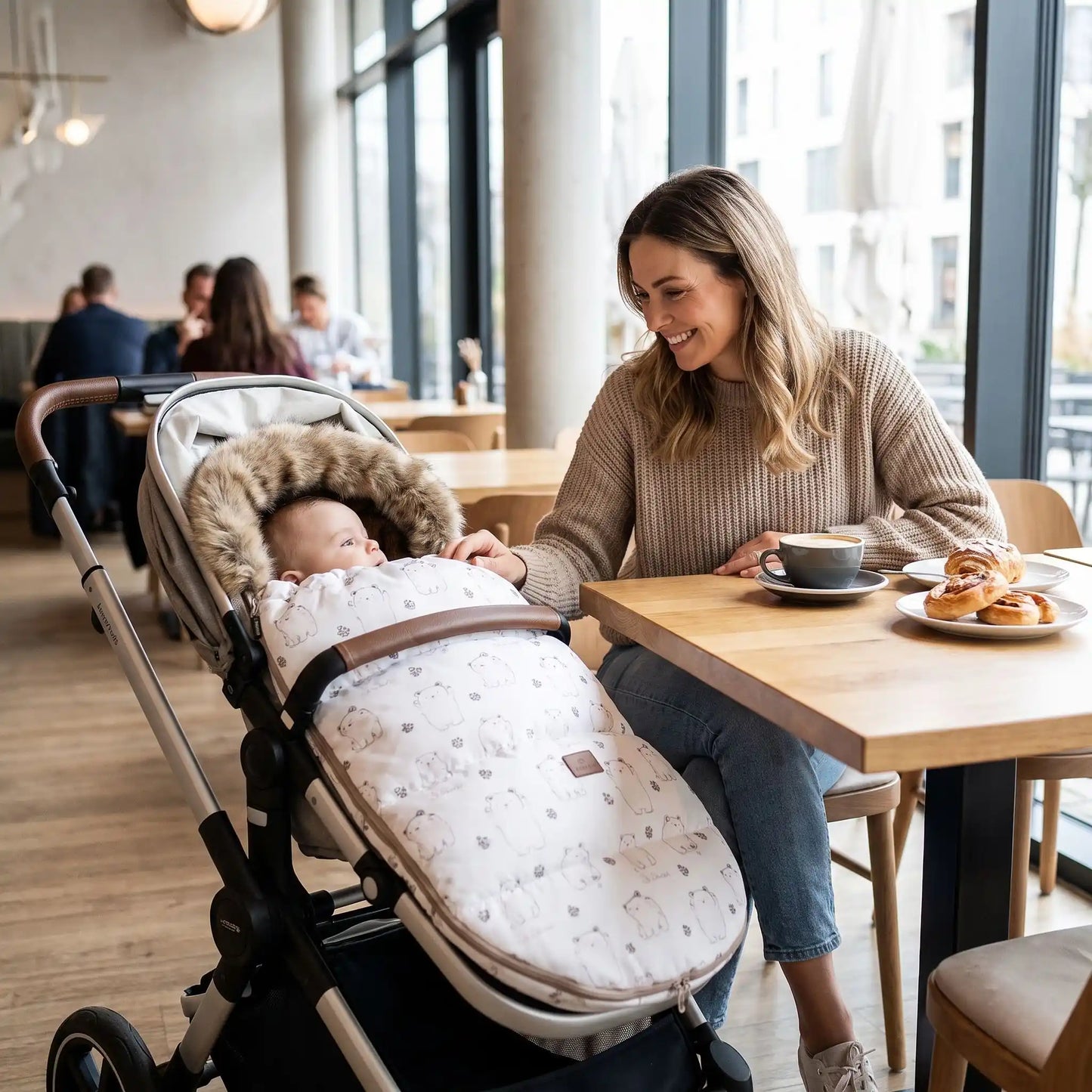 Maman au restaurant avec bébé dans chancelière poussette beige ours