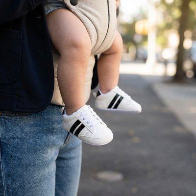 Maman avec bébé portant chaussure bebe blanc noir