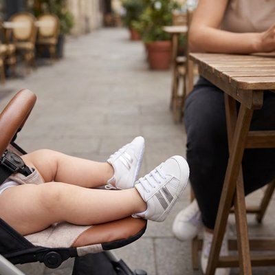 Maman avec bébé présente chaussure bebe blanc gris