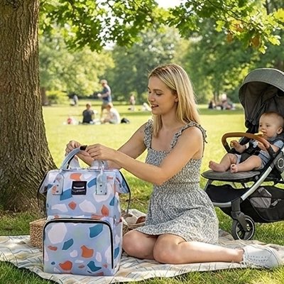 Maman et bébé au parc avec sac a langer violet fleuri