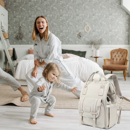 maman bébé jouent en chambre près sac à langer blanc