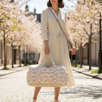 maman dans allée fleuri avec sac à langer en main